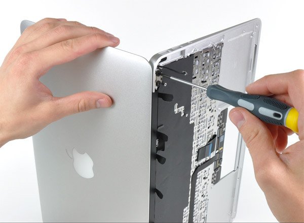 Kỹ thuật viên chuyên nghiệp đang kiểm tra phần cứng của một chiếc MacBook để chẩn đoán lỗi