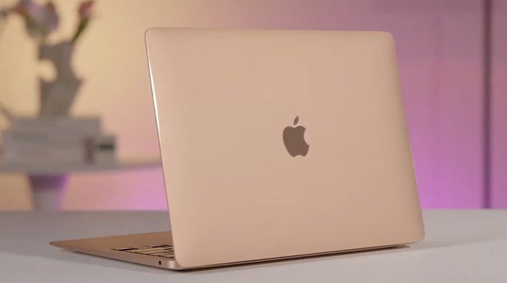 MacBook Air M1 2020 màu vàng đồng trên bàn làm việc, làm nổi bật thiết kế mỏng nhẹ và vỏ kim loại sáng bóng của máy