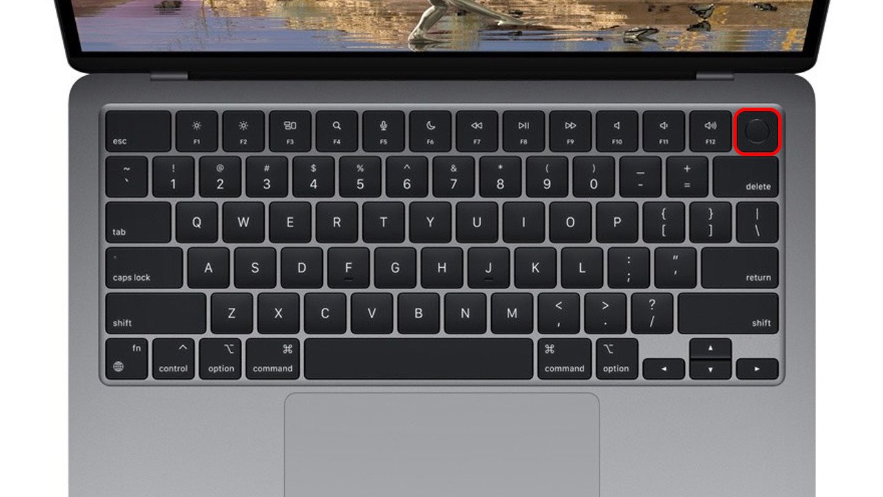 Người dùng nhấn giữ nút Touch ID trên bàn phím MacBook Air M1 để bật máy