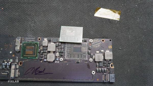 Thợ sửa đang tháo rời một chiếc CPU lỗi ra khỏi bo mạch chủ của MacBook để chuẩn bị thay thế